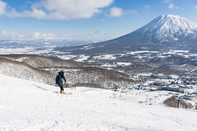 Mt. Yotei view on a clear, blue skied day following a snowboarder down to Grand Hirafu.