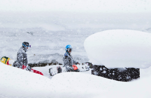 Very happy snowboarders heading to the slopes to make the most of the powder snow.